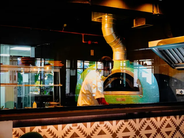 Cocina de restaurante con horno de pizza encendido.